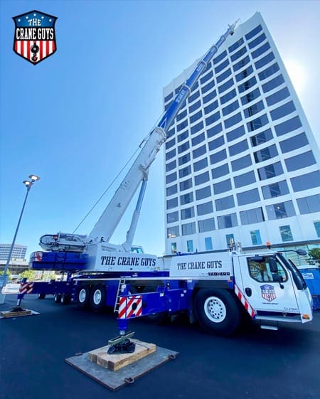 crane lifting onto the rooftop of tall building